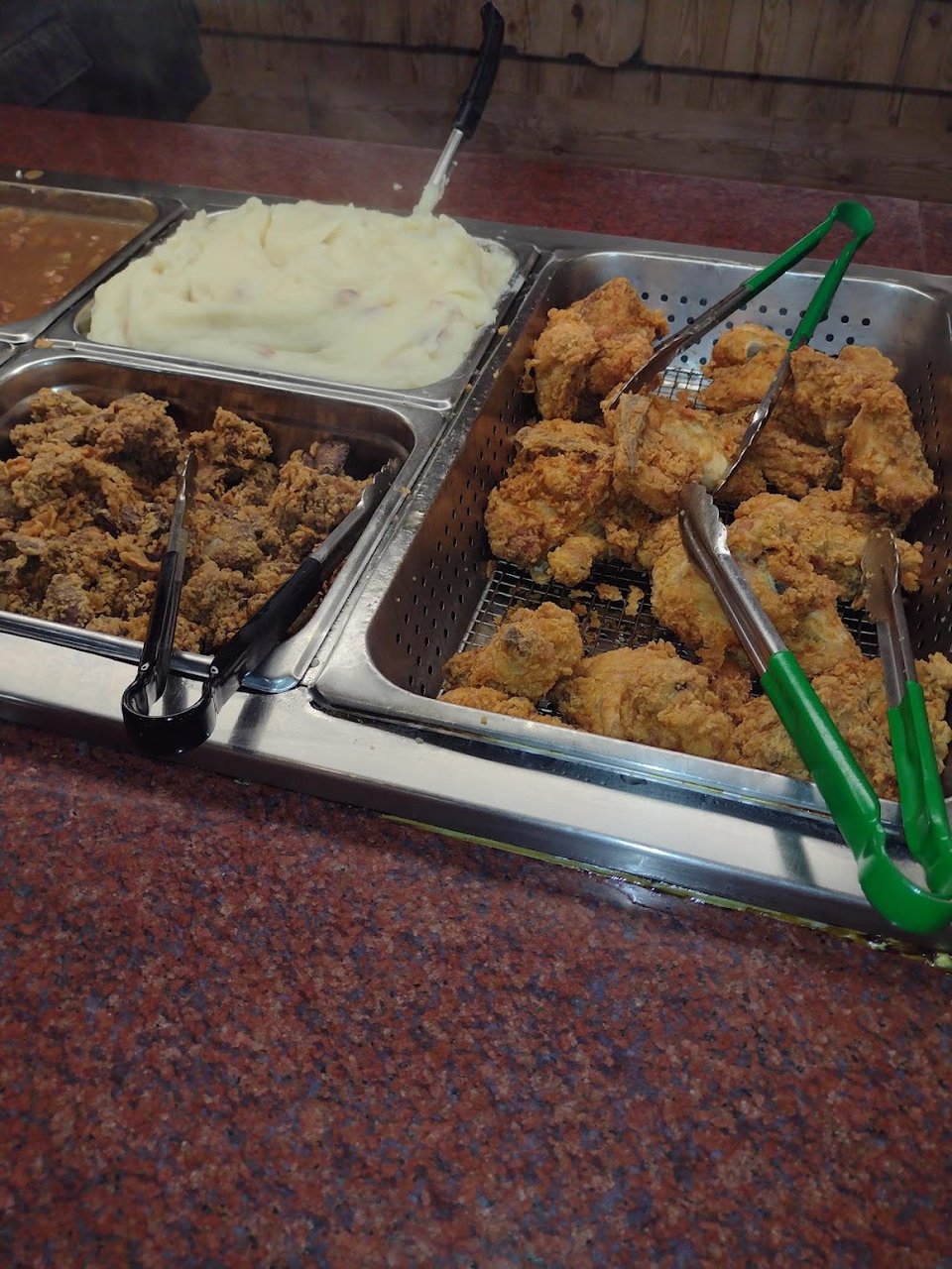 Buffet selection with fried chicken and side dishes.